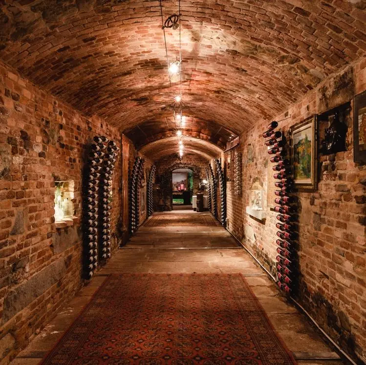 Cantina storica a volta di mattoni con le bottiglie di casa Balbiano