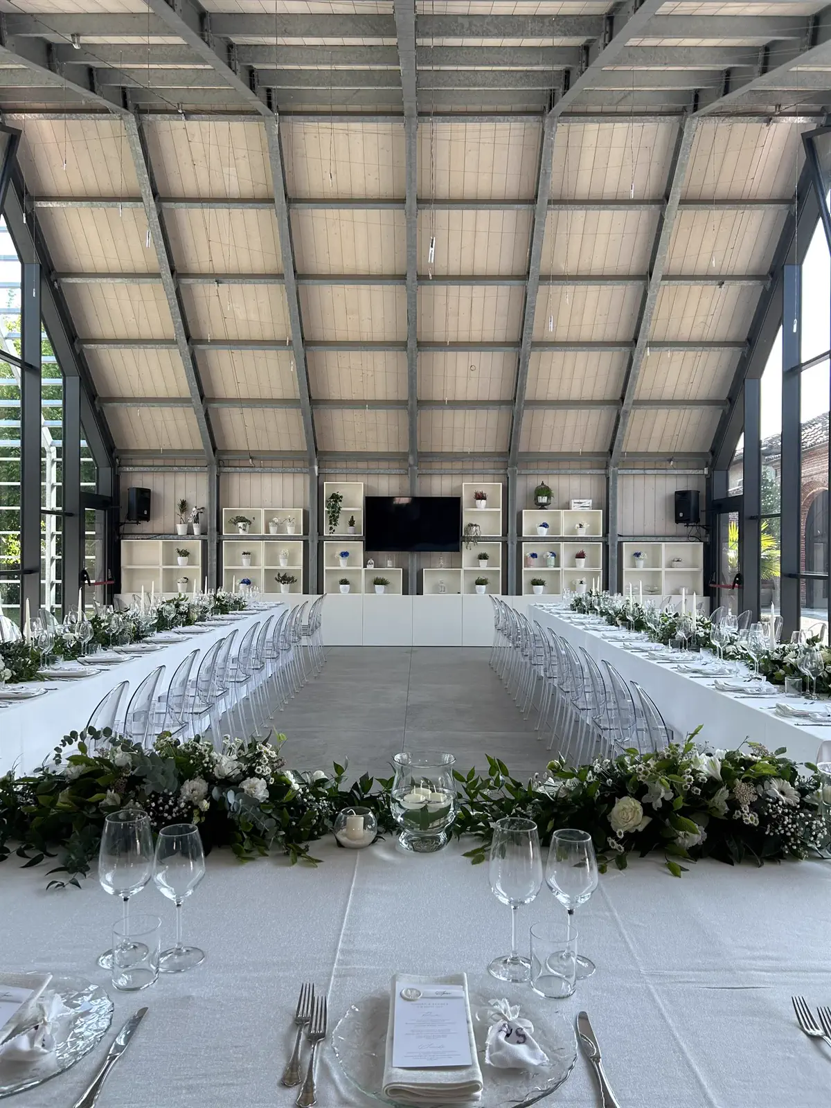 Tavolo imperiale apparecchiato per un ricevimento di matrimonio nella sala vetrata