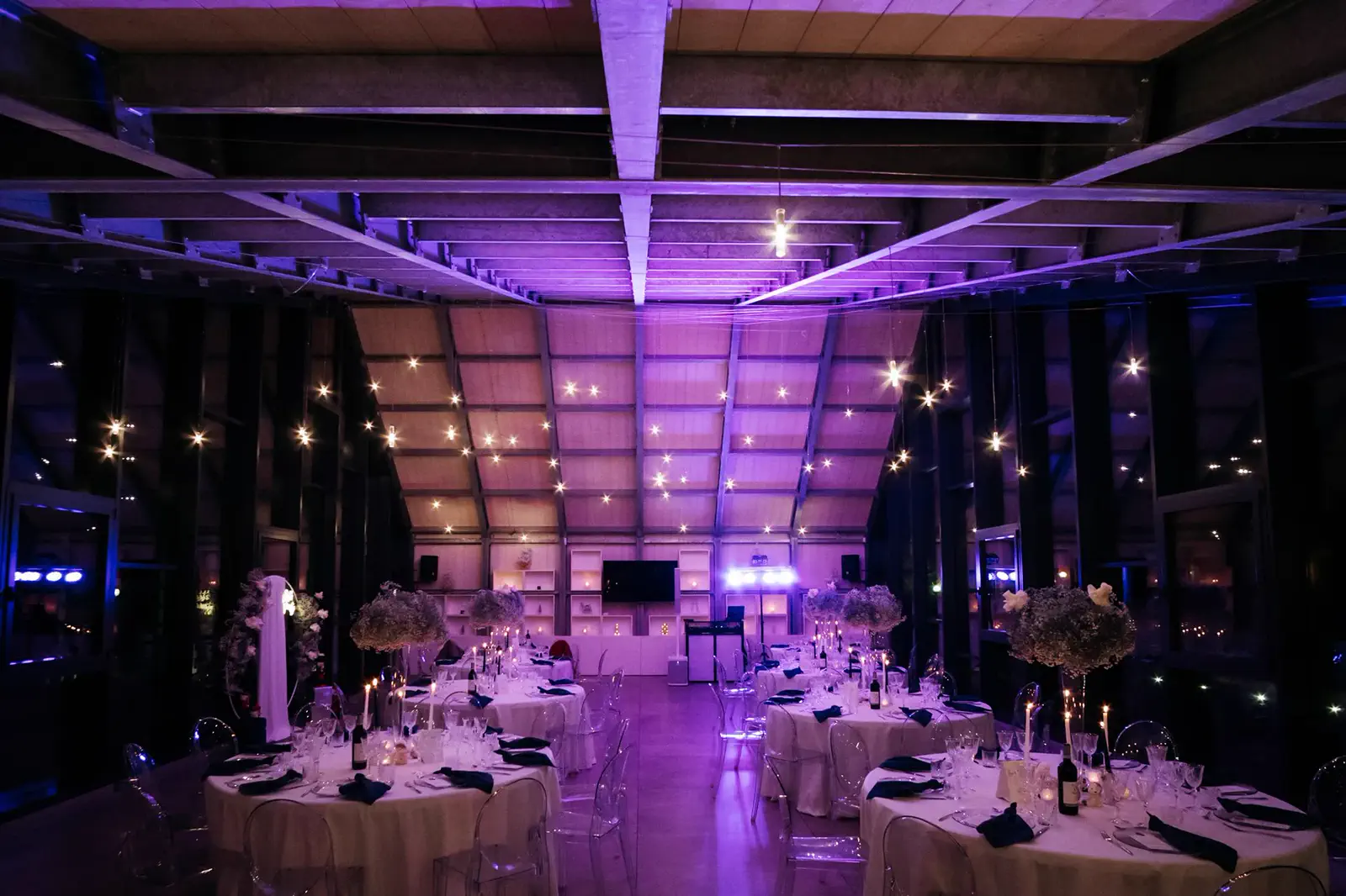 Sala vetrata illuminata di viola e allestita per una festa di compleanno