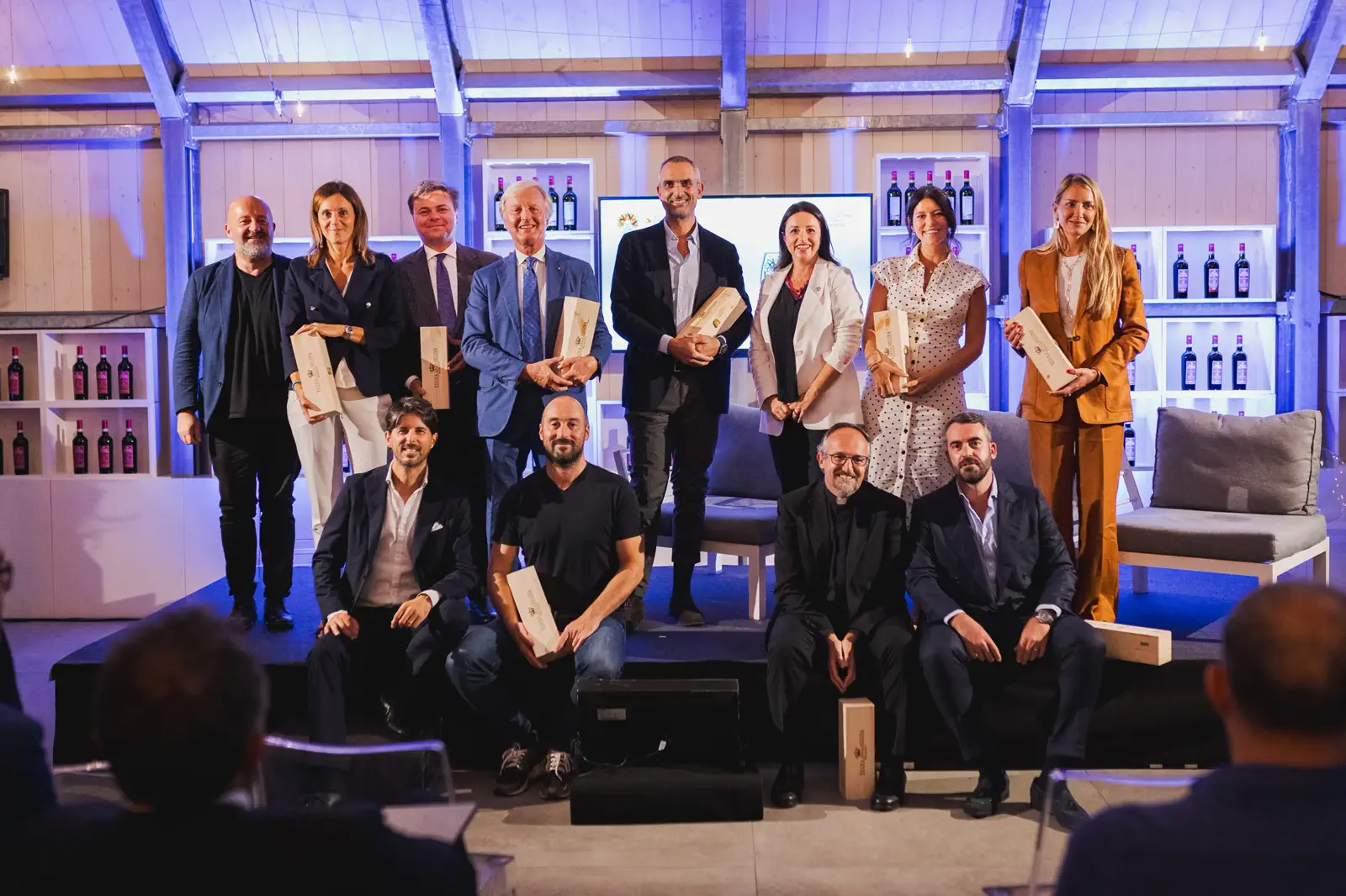 Gli ospiti di un evento aziendale riuniti sul palco nella sala vetrata di Villa Balbiano